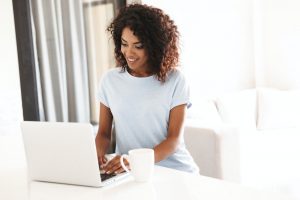 Smiling african woman using laptop computer